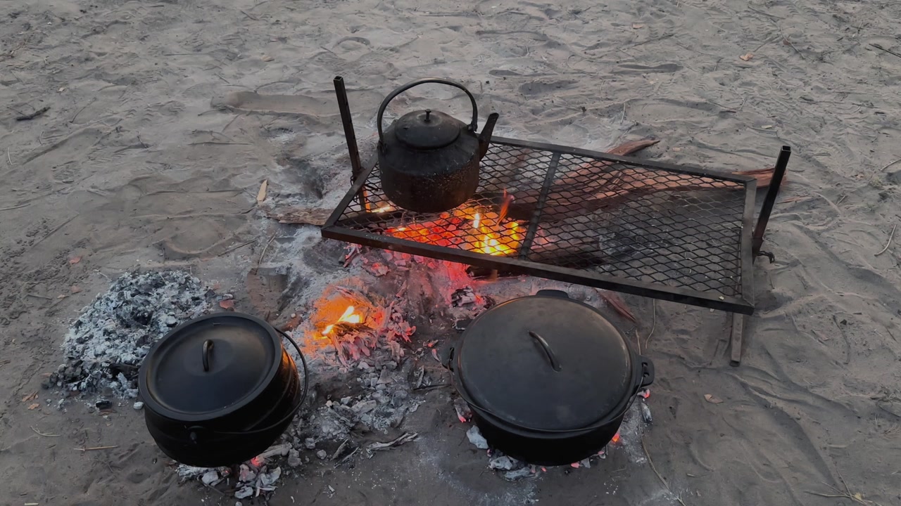 Old tea pot on camping fire at night. The concept of camping, adventure and travel.