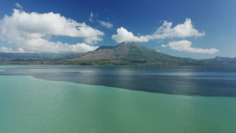 día claro y soleado en el lago batur con el monte batur en el fondo, cambio de color en el agua debido al azufre, antena