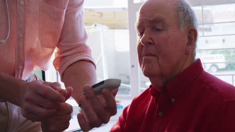 médico examinando um homem idoso em um lar de idosos