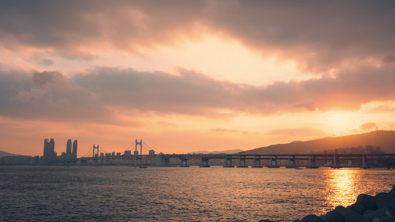 부산의 화려한 하늘과 함께 gwangwang 다리 또는 gwangdaegyo를 볼 수 있는 생생한 분홍색 일몰, 산 위에 해가 지는