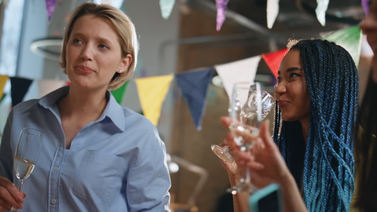 행복한 팀은 사무실에서 생일파티를 즐기고, 근접으로, 동료들이 안경을 들고 있습니다.