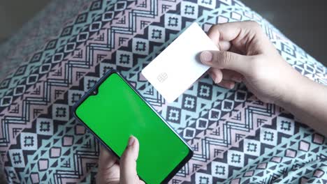 woman using a smartphone and credit card for online payment