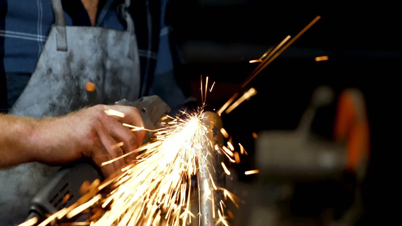 кузнец, использующий шлифовальную машину на стержне 4k