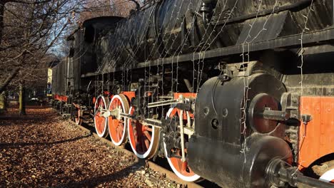 antique steam locomotive and wagons on railway in park on winter day