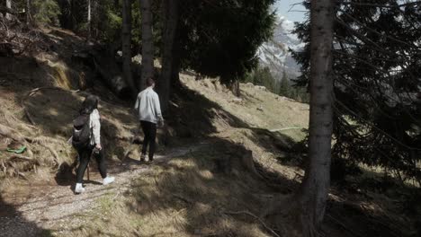 Couple-Trekking-On-The-Forest-Trail-Near-Dolomite-In-Italy