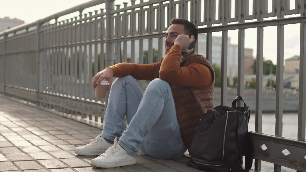 Man Sitting on Sidewalk Phone Calling