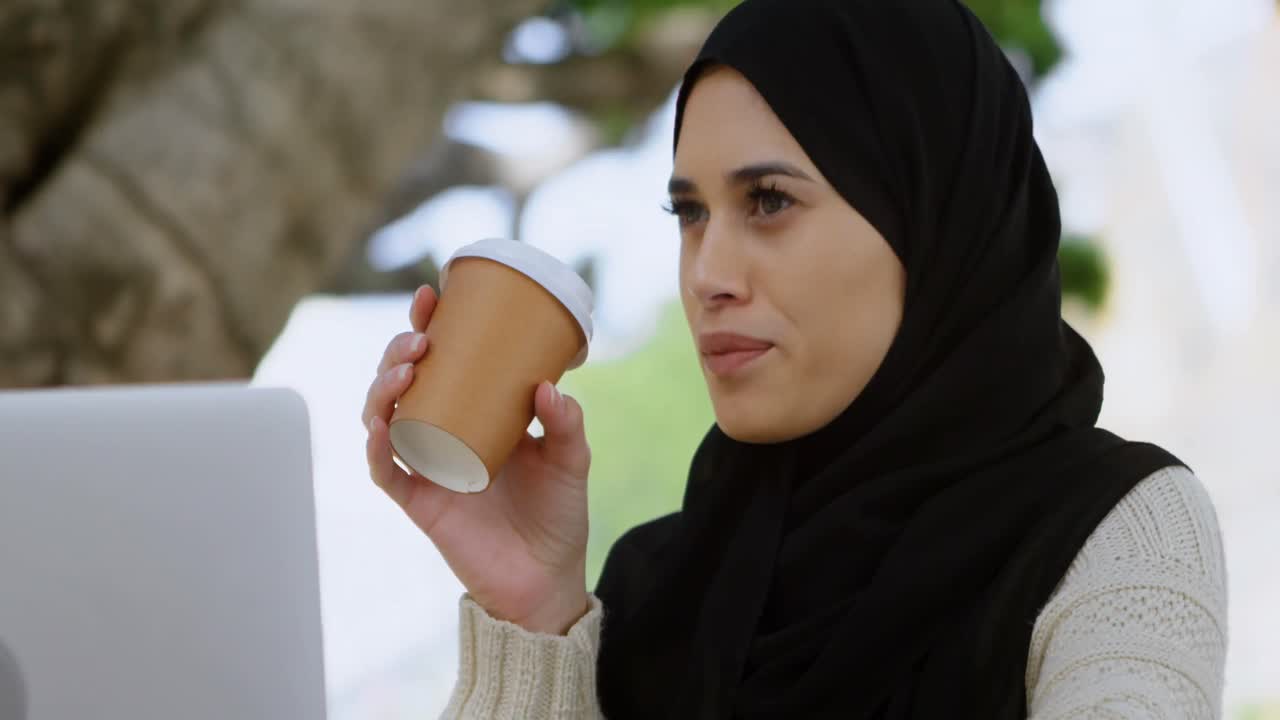 Woman in hijab having coffee 4k