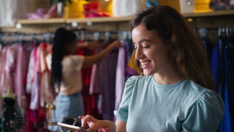 female owner or worker in fashion clothing store checking stock with digital tablet