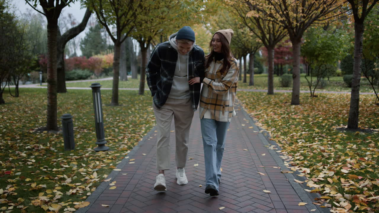una pareja feliz y enamorada teniendo un paseo romántico con alegría y diversión en el parque foliage.