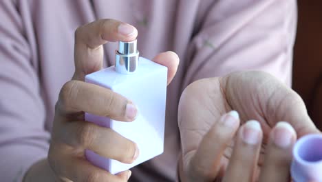 mujer aplicando perfume