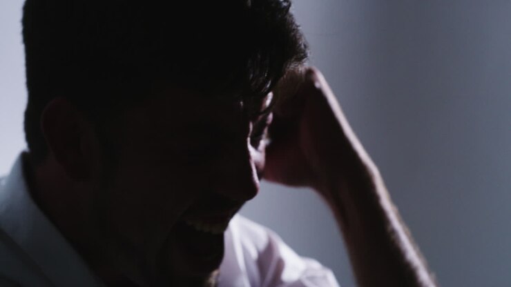 Closeup silhouette of an angry man screaming alone