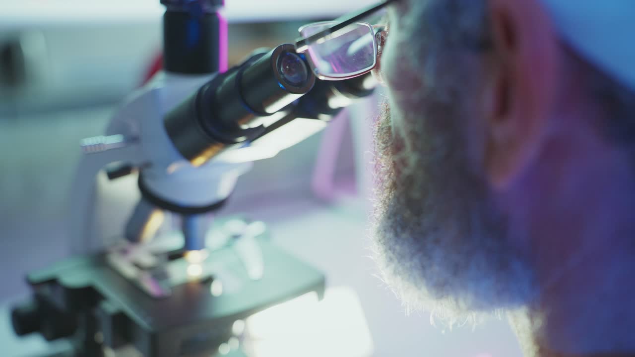 Close-up of Scientist Looking Through a Microscope in a Lab