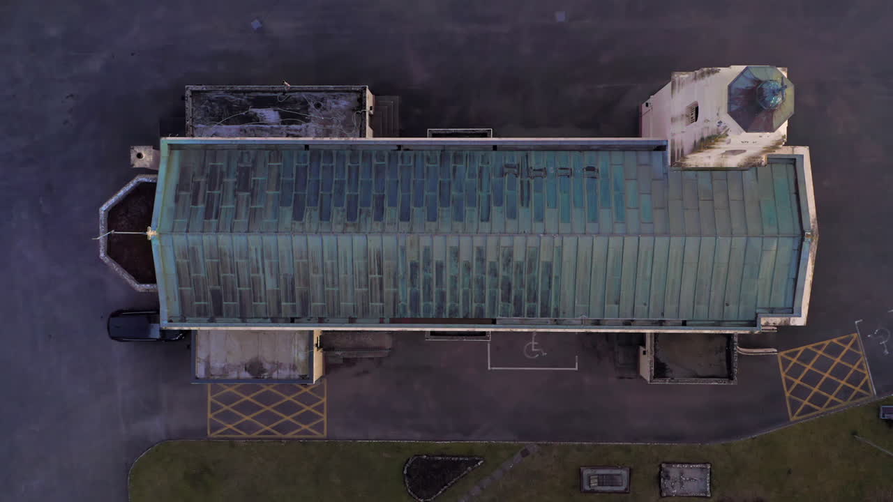 Close aerial top shot rising from glass roof church building in Clarinbridge reflecting soft sunset tones in structure