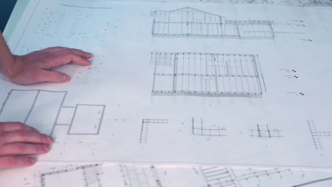 person pointing to architectural plans