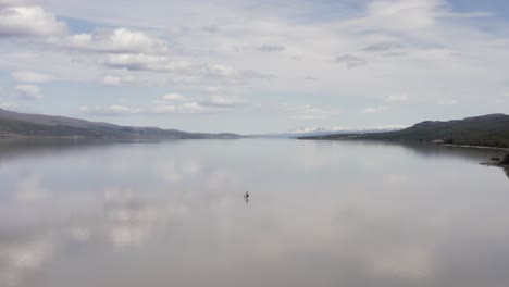 antena en el lago lagarfljot en islandia con un hombre solitario en una tabla de remo