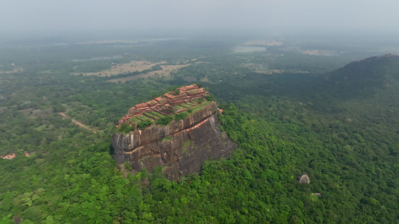 Sri Lanka dronebane rundt Sigiriya Rock Fortress som viser toppen av ruinene over endeløst grønt jungellandskap