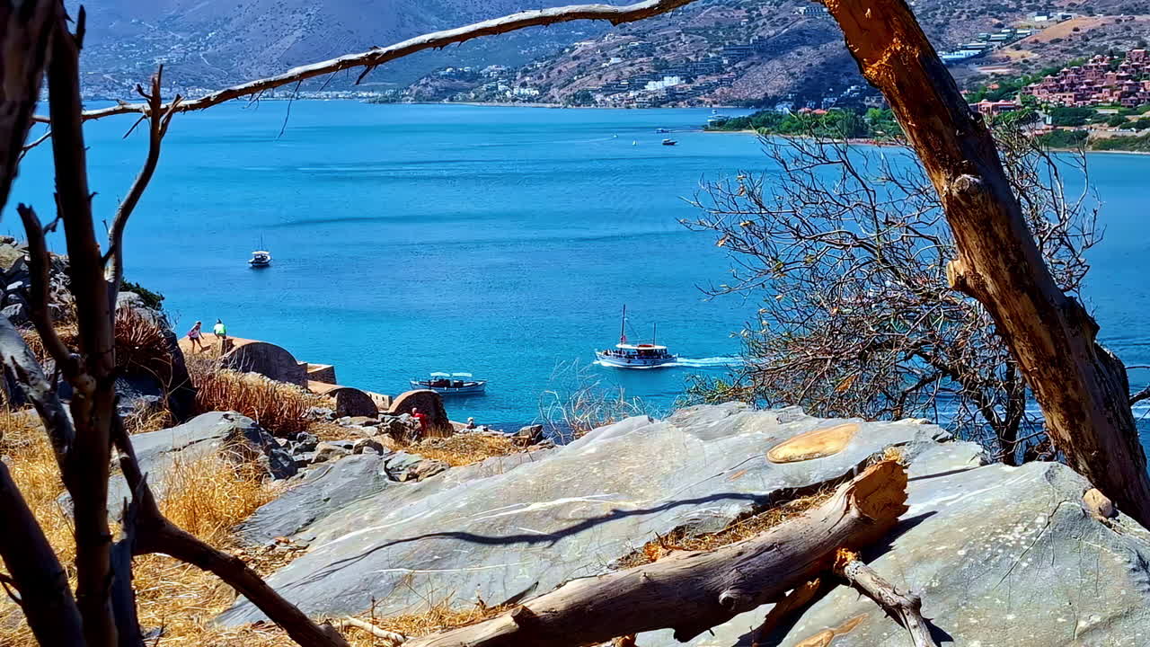 Spinalonga fortress shoreline view with tour boats