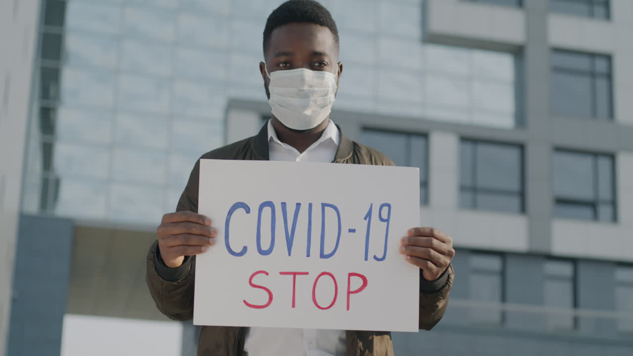 Man Holding Anti-COVID-19 Sign