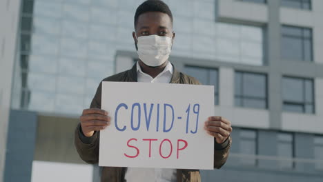 Man Holding Anti-COVID-19 Sign