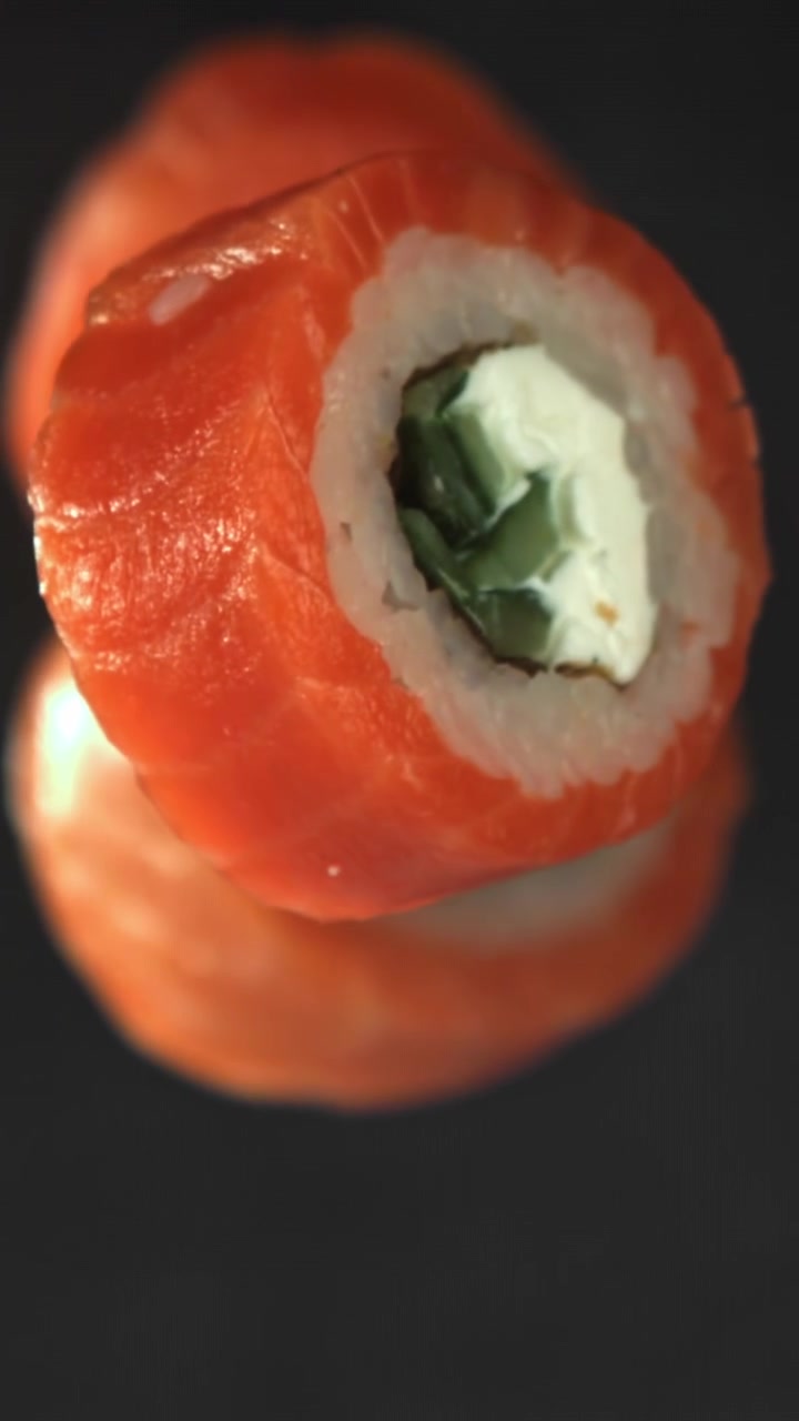 Lohisushirullan lähikuva pyörimässä tummalla taustalla