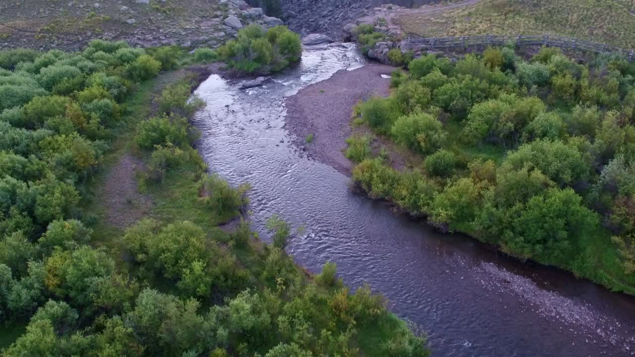 Drone view of a small river transforming in a waterfall on top of a creek