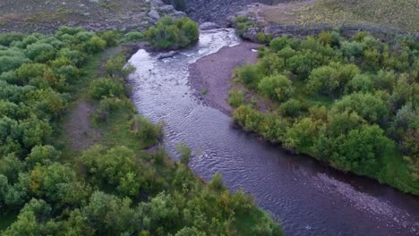 drone view of a small river transforming in a waterfall on top of a creek
