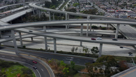 Slowly-Circling-Aerial-View-over-Judge-Pregerson-Interchange-Highway-showing-multiple-Roads-with-little-car-traffic-in-Los-Angeles-during-times-of-Coronavirus-Covid19-Pandemic-on-sunny-day