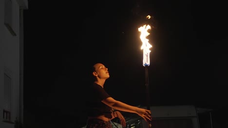 la oscuridad de la noche es el telón de fondo perfecto para que este artista realice un emocionante espectáculo de fuego