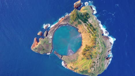 high angle aerial riser above vegetated uninhabited vila franca islet, azores