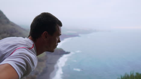 with the ocean in sight, a young man practices sun salutation yoga on a mountain, uniting meditation and exercise for a wholesome lifestyle. fitness, sport, and well-being intertwine