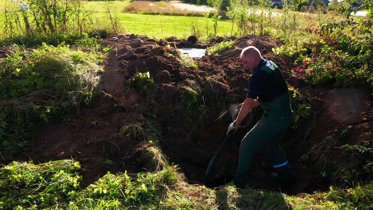 homem caucasiano de 50 anos cava terreno no quintal para construção de fumeiro