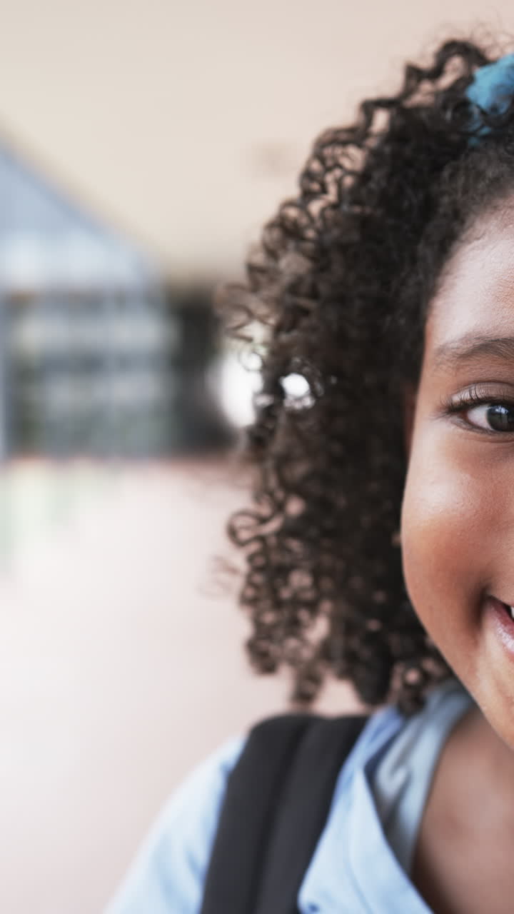 Vertical video: Standing outdoors, smiling child with backpack, ready for school