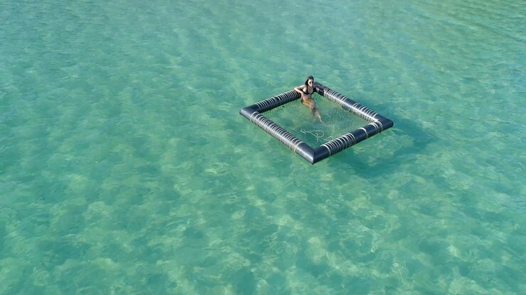 beautiful girl sitting and tanning in a floating device in the ocean, Koh Kood, Thailand