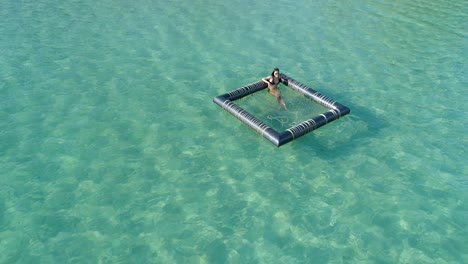 Schönes-Mädchen,-Das-In-Einem-Schwimmenden-Gerät-Im-Meer-Sitzt-Und-Sich-Bräunt,-Koh-Kood,-Thailand