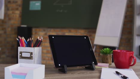 Blick-Auf-Ein-Digitales-Tablet-Und-Andere-Schulmaterialien-Auf-Dem-Tisch-Im-Klassenzimmer-Der-Schule