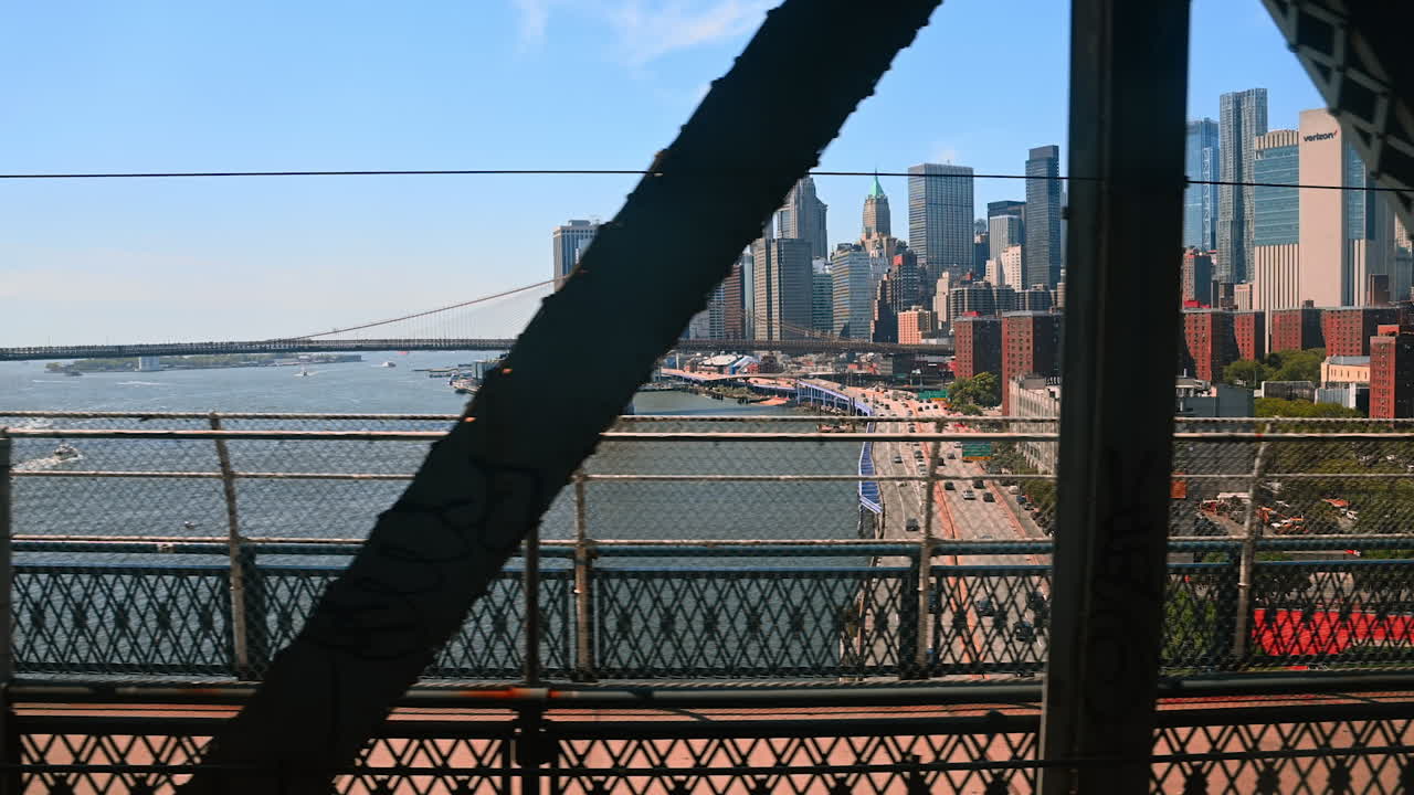 New Jersey, USA, 19 August 2025: Moving by the Manhattan Bridge. View on the Brooklyn Bridge and New York skyline at backdrop