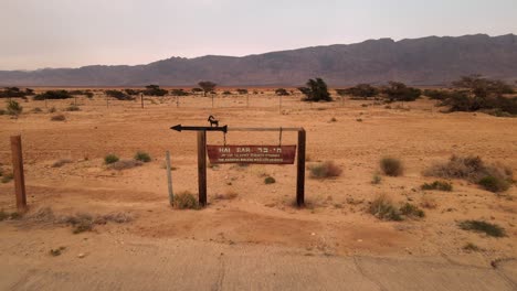 paso elevado bajo un pequeño cartel de información de la barra hai con un impresionante telón de fondo con una gran cadena montañosa