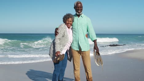 Senior-couple-standing-together-at-the-beach