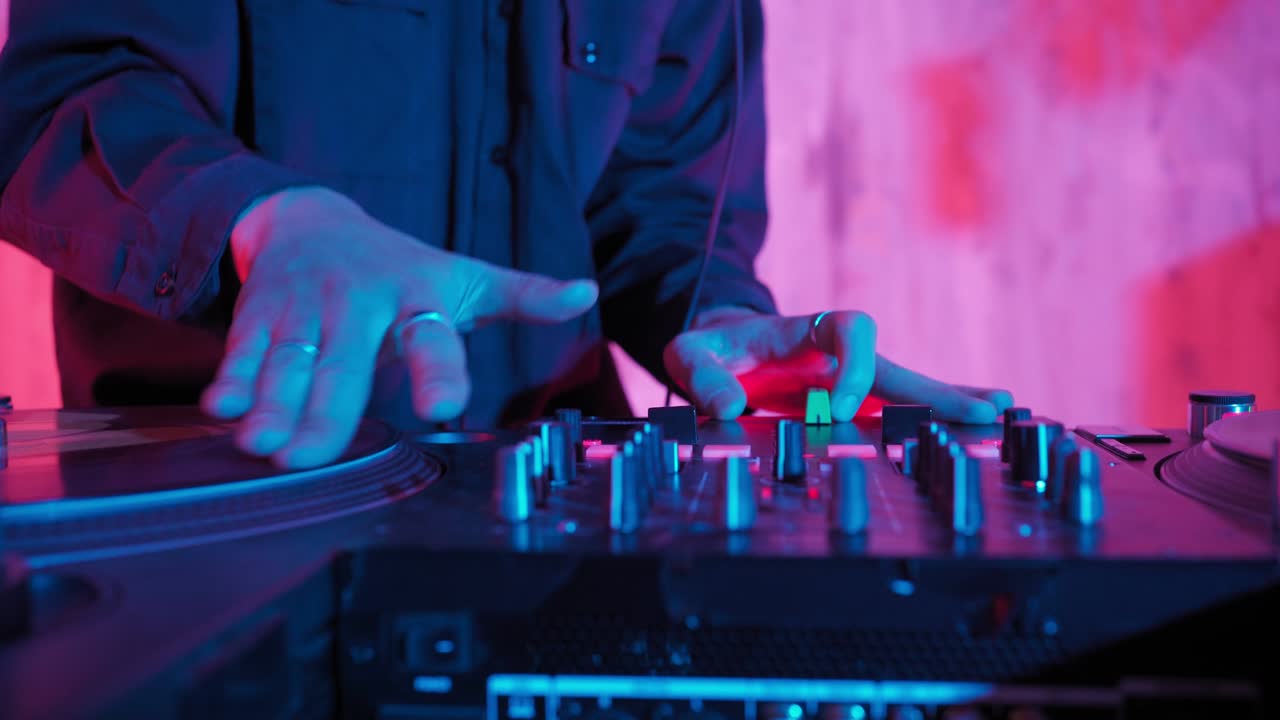 un dj moderno de apariencia asiática realiza una pista de música con iluminación de neón.