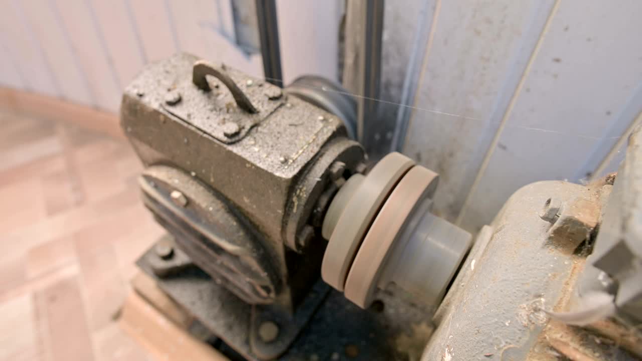 먼지와 으로 인 오래된 전기 모터는 벨트 드라이브를 가진 카르단 기어 박스를 통해 두 개의 스레드 리를 다른 메커니즘으로 회전시니다.