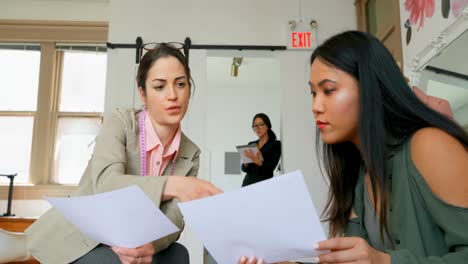 Fashion-designer-discussing-sketch-with-a-female-customer-4k