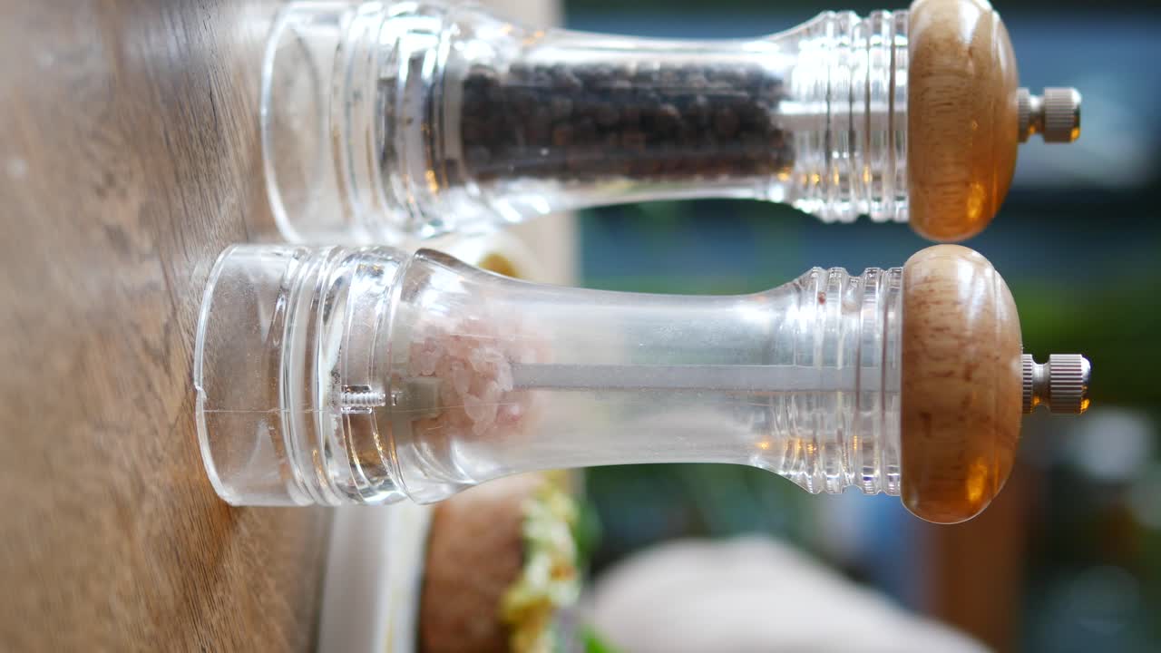 Salt and Pepper Grinders on a Wooden Table