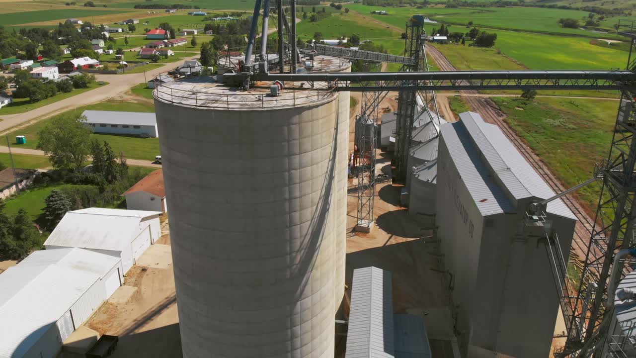 Aerial tilt-up and boom-down over tall grain silo at rural North Dakota elevator complex