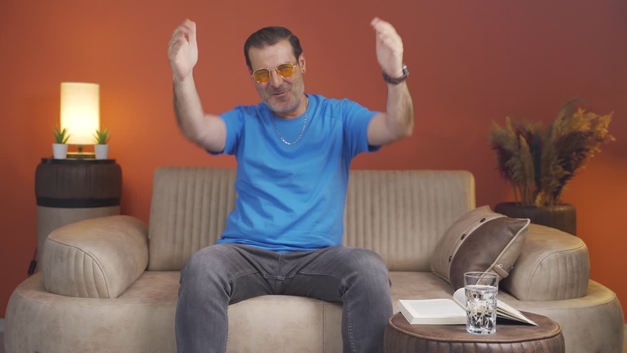 hombre aplaudiendo emocionado a la cámara.