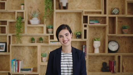 Retrato-De-Una-Joven-Hermosa-Pasante-Riéndose-Alegremente-Con-Los-Brazos-Cruzados-Sintiéndose-Optimista-En-El-Lugar-De-Trabajo