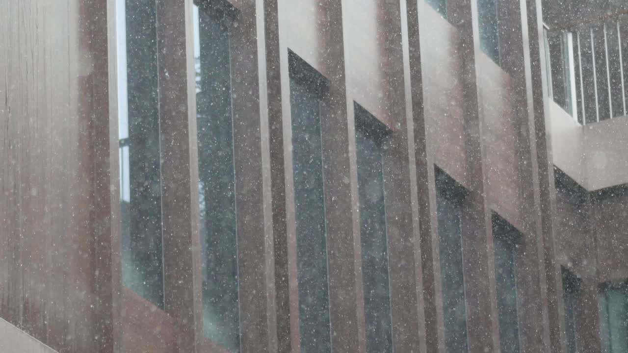 많은 창문 을 가진 현대적 인 건물 에 비 가 내리고 있다