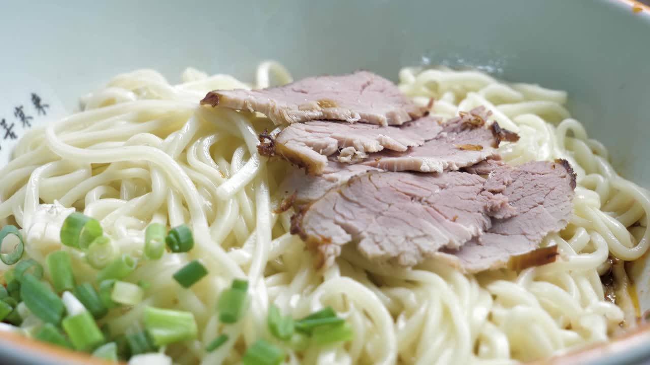 Close up of typical Chengdu food- Mi Xian noodle with braised pork slices and spring onion, China