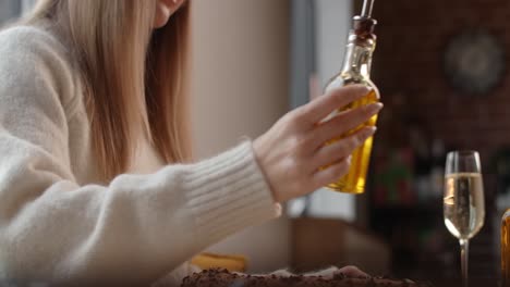 woman pouring oil over cake