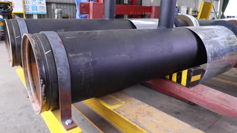 large diameter steel pipes on a lifting machine in a fabrication plant