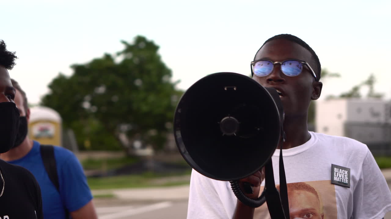 Young black man speaking in megaphone at Black Lives Matter protest